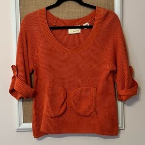 Scoop neck orange sweater with bow pockets. Size S. From Anthropologie.